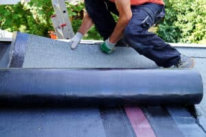 Worker installing a flat roofing system