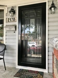 The porch of a home with a black storm door