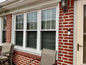 A brick home with three double-hung windows next to each other